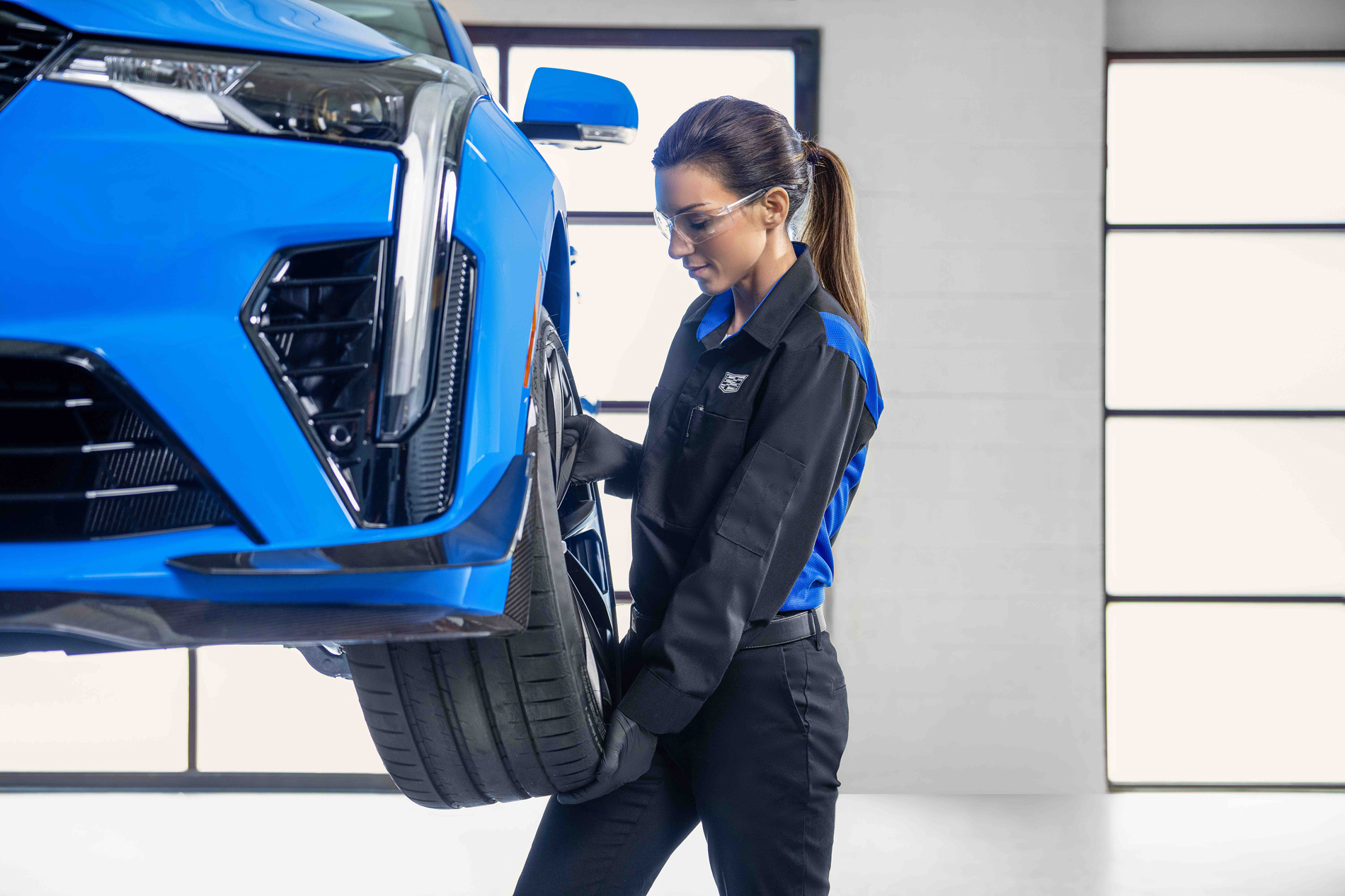 Cadillac service technician removing wheel from car